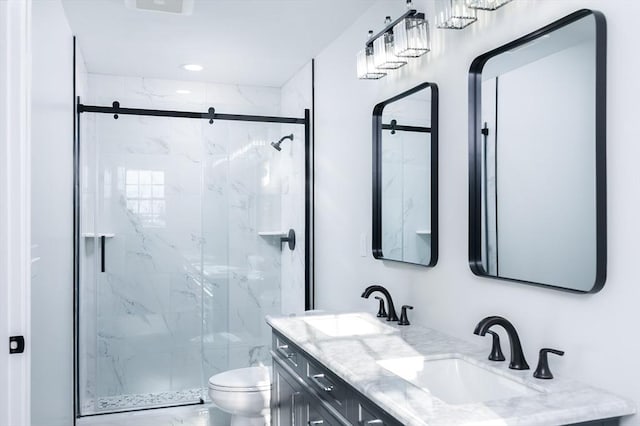 bathroom with a marble finish shower, a sink, toilet, and double vanity