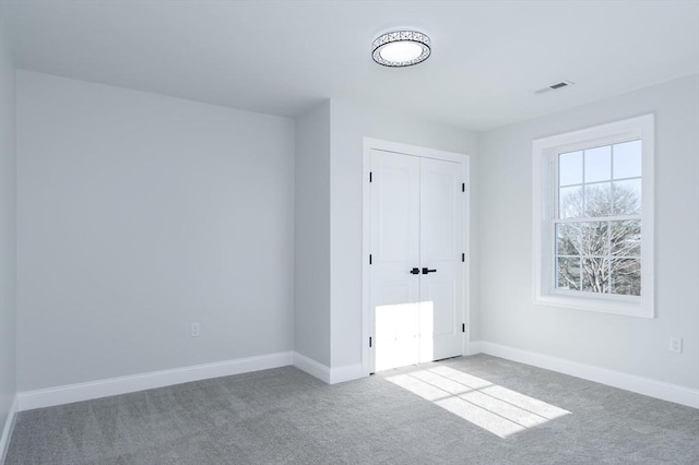 unfurnished bedroom featuring visible vents, a closet, baseboards, and carpet flooring