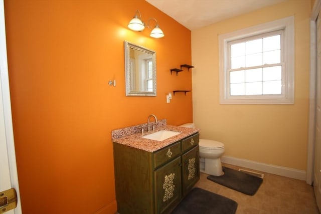 bathroom featuring vanity, toilet, visible vents, and baseboards