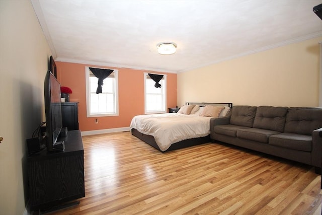 bedroom featuring baseboards, light wood finished floors, and ornamental molding