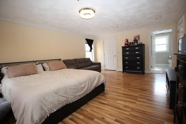 bedroom featuring light wood finished floors, connected bathroom, baseboards, and ornamental molding