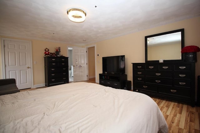 bedroom with baseboards, light wood-style floors, and ornamental molding