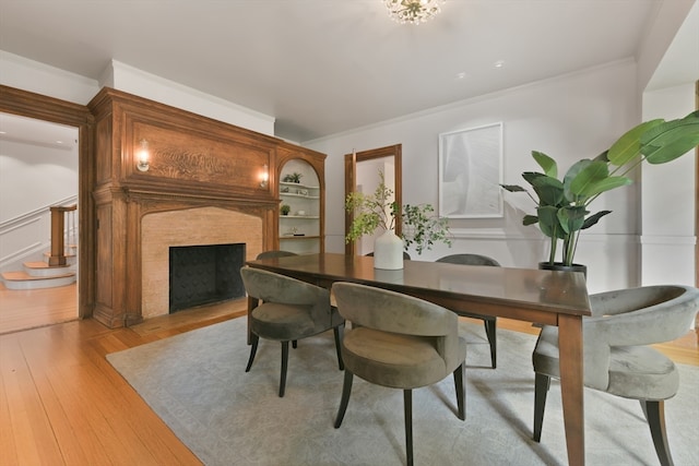 dining area with ornamental molding and light hardwood / wood-style floors