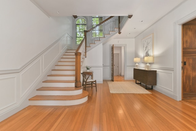 stairs with crown molding and hardwood / wood-style floors