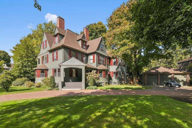 victorian-style house featuring a front lawn and a garage