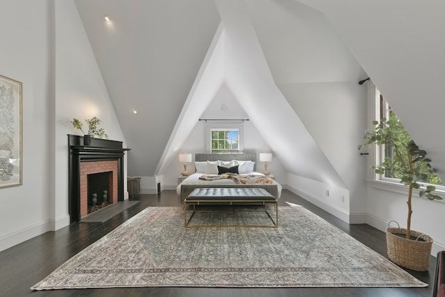 interior space featuring vaulted ceiling, a brick fireplace, and dark hardwood / wood-style flooring