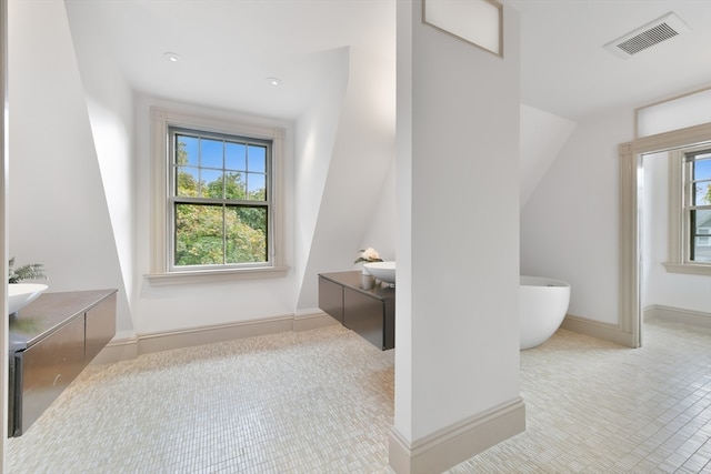 bathroom with vanity, a washtub, and tile patterned flooring