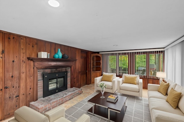 living room featuring a brick fireplace and wood walls