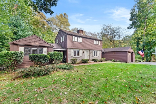 view of front of home featuring a front yard, an outdoor structure, and a garage