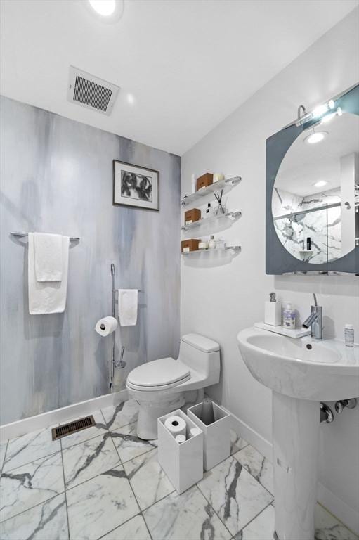 26 Sherwood Rd, Swampscott, MA 01907 - bathroom featuring marble look tiles, baseboards, toilet, and a sink