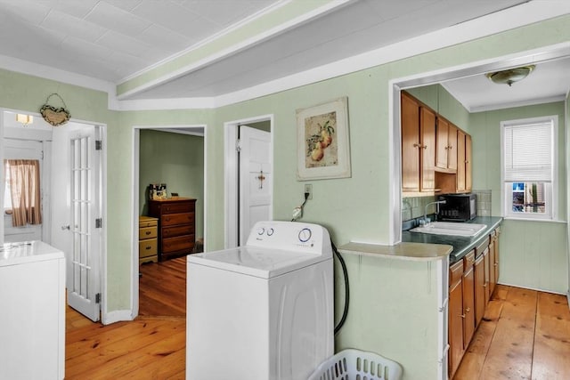 laundry room with washer / clothes dryer, a healthy amount of sunlight, and light wood-type flooring