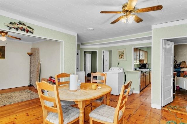 dining area featuring ceiling fan, washer / clothes dryer, sink, and light hardwood / wood-style flooring