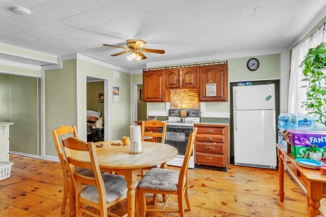 kitchen featuring ceiling fan, white appliances, and light hardwood / wood-style floors