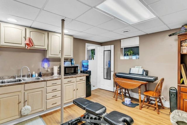 exercise room with light hardwood / wood-style floors, sink, and a drop ceiling