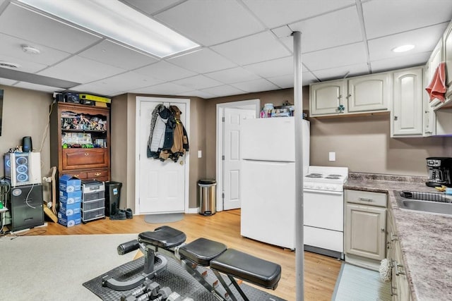 exercise room featuring sink, a paneled ceiling, and light hardwood / wood-style flooring