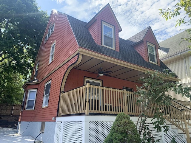 view of side of property with a balcony and ceiling fan