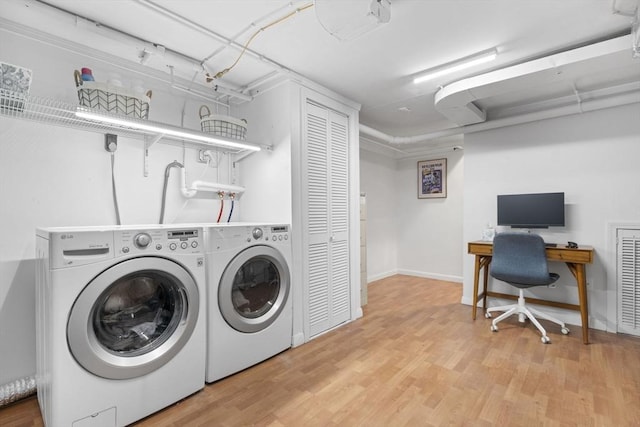 laundry area with laundry area, light wood finished floors, and separate washer and dryer