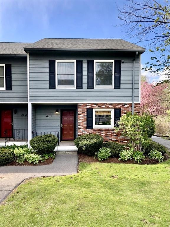 view of front of home featuring a front lawn and brick siding