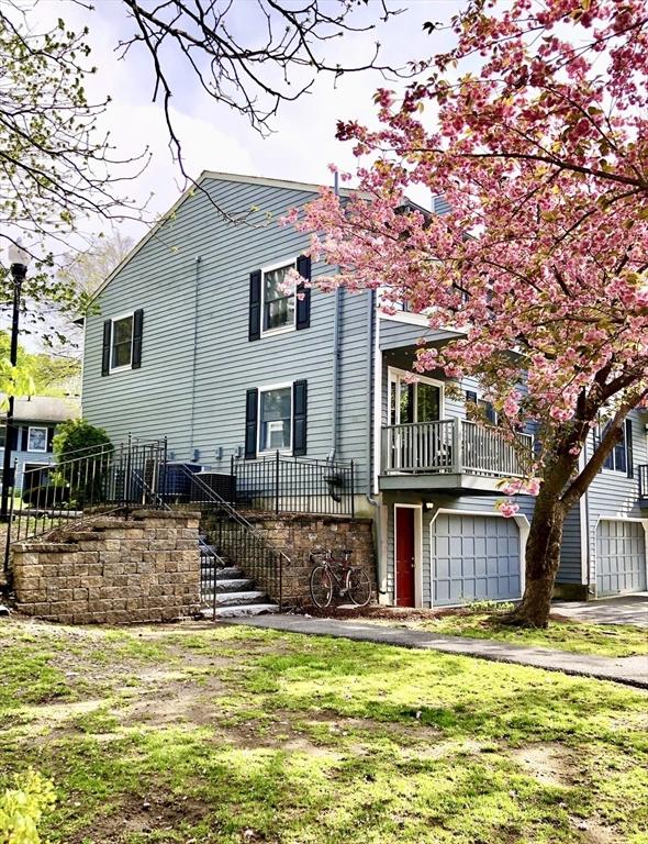 view of front of property with a garage, driveway, and stairs