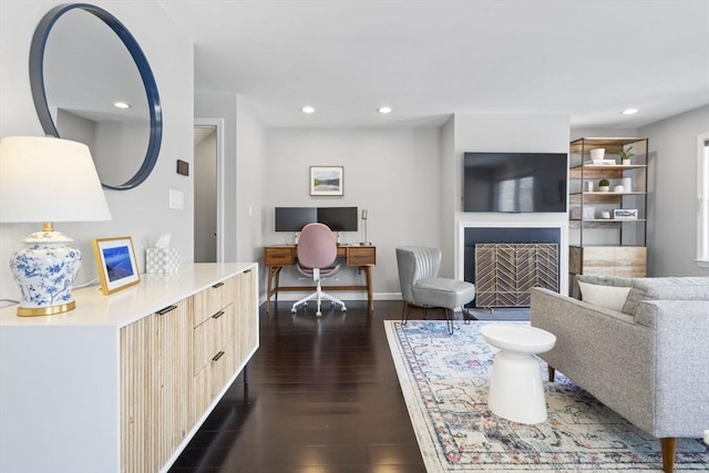 living room featuring baseboards, a fireplace with flush hearth, dark wood finished floors, and recessed lighting