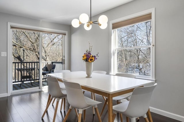 dining area with a wealth of natural light, dark wood-style flooring, and baseboards