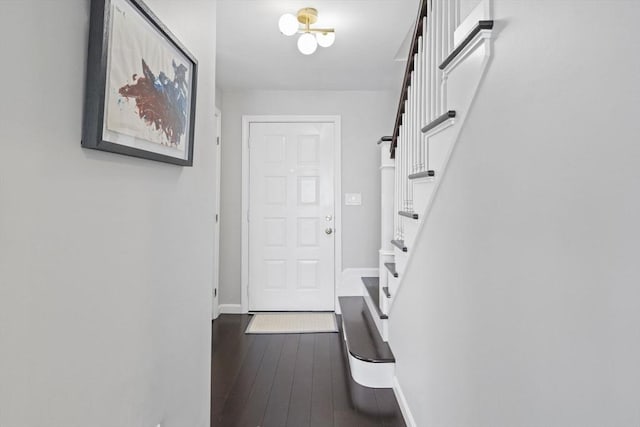 entryway with stairs, wood-type flooring, and baseboards