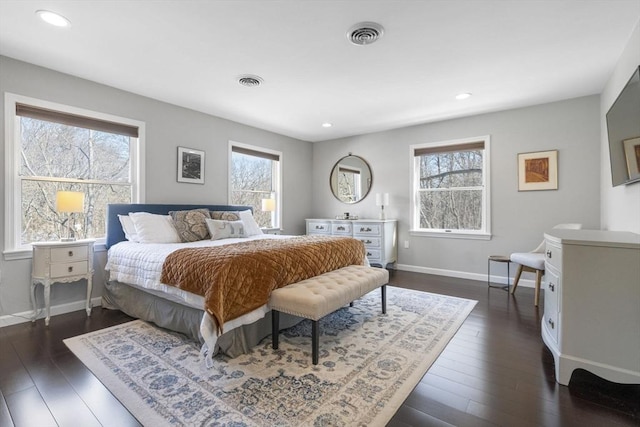 bedroom with dark wood-style floors, baseboards, multiple windows, and visible vents