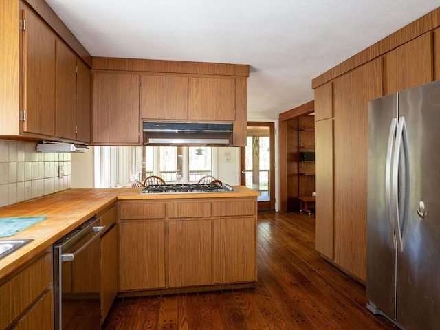 104 Tower Rd, Lincoln, MA 01773 - kitchen featuring decorative backsplash, appliances with stainless steel finishes, dark wood finished floors, wood counters, and under cabinet range hood