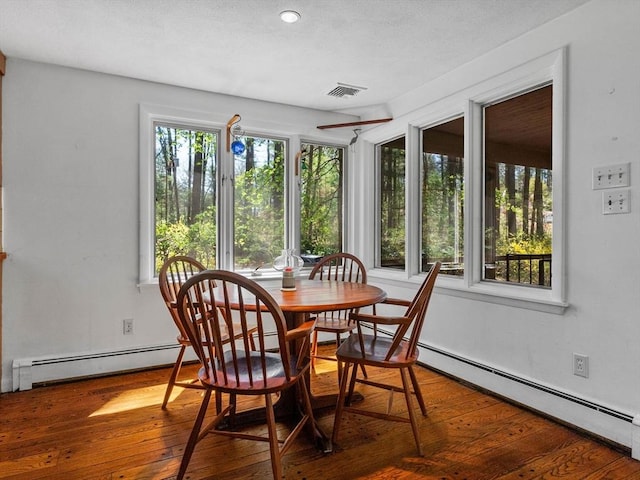 104 Tower Rd, Lincoln, MA 01773 - dining space with visible vents, a baseboard radiator, wood-type flooring, and a wealth of natural light