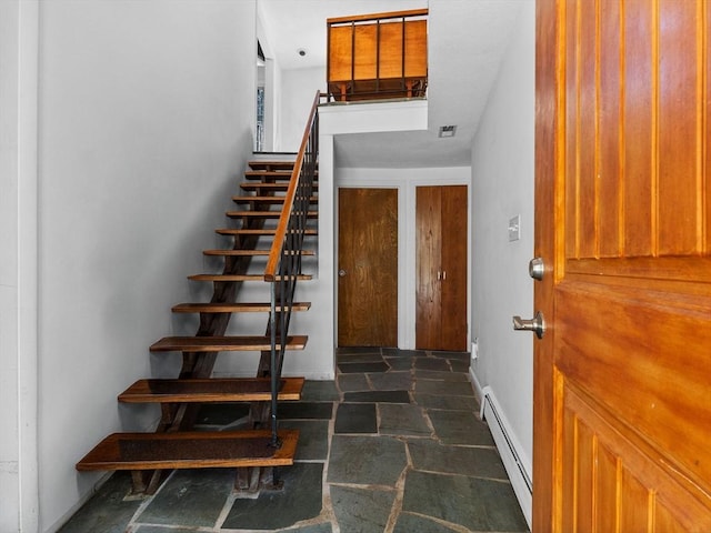 104 Tower Rd, Lincoln, MA 01773 - stairs featuring baseboards, baseboard heating, stone finish flooring, and visible vents