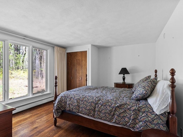 104 Tower Rd, Lincoln, MA 01773 - bedroom with a baseboard heating unit, wood finished floors, and a closet