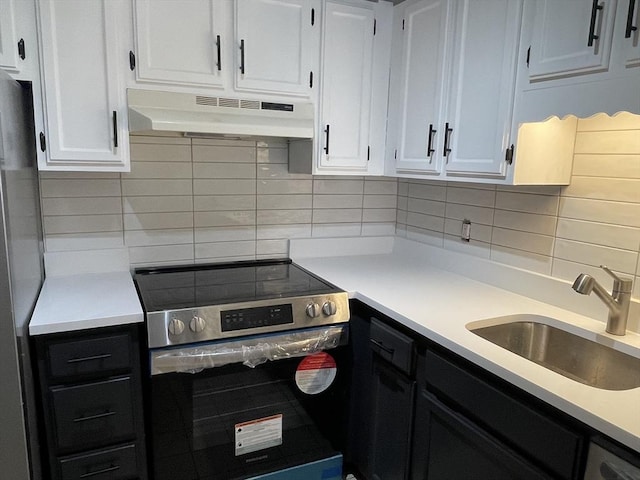 kitchen with electric stove, white cabinetry, sink, and backsplash