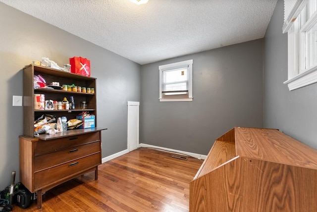 interior space featuring hardwood / wood-style flooring and a textured ceiling