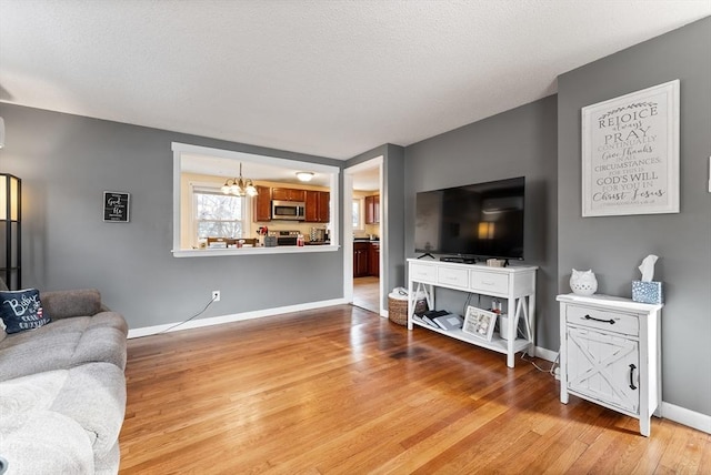 living room with light hardwood / wood-style floors and a chandelier