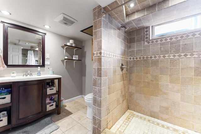 bathroom featuring vanity, tiled shower, tile patterned floors, and toilet