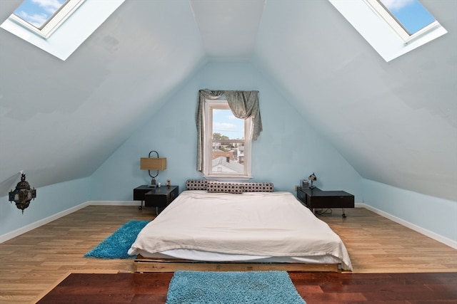 bedroom featuring wood-type flooring and lofted ceiling with skylight