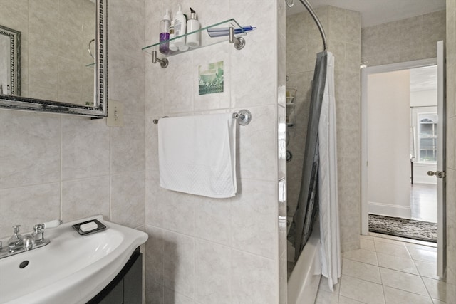 bathroom with shower / tub combo, tile patterned flooring, vanity, and tile walls