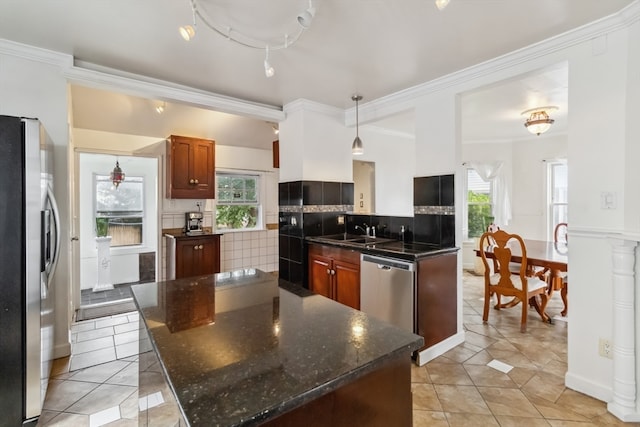 kitchen featuring a wealth of natural light, appliances with stainless steel finishes, tasteful backsplash, and a kitchen island