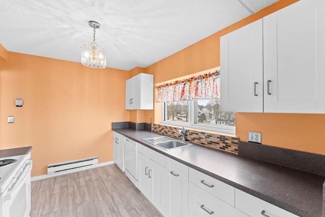 kitchen featuring dark countertops, tasteful backsplash, baseboard heating, white appliances, and a sink