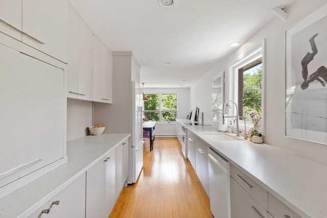 166 Quinapoxet Ln, Worcester, MA 01606 - kitchen with white appliances, a sink, light wood finished floors, light countertops, and white cabinets