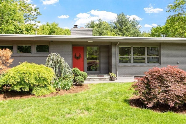 166 Quinapoxet Ln, Worcester, MA 01606 - view of front of property featuring a chimney, a front lawn, and brick siding