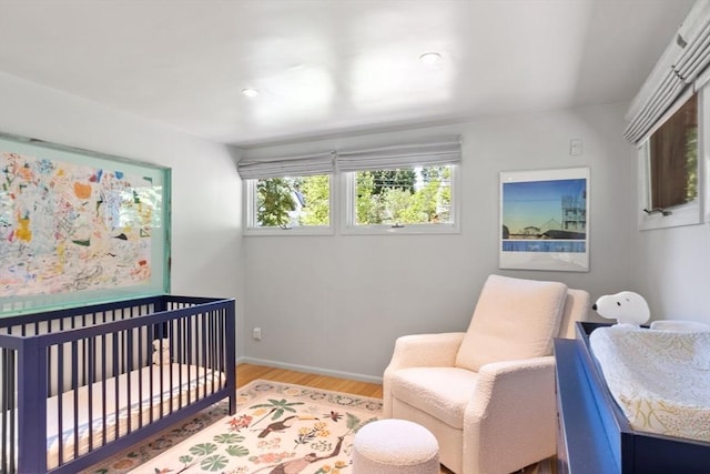 166 Quinapoxet Ln, Worcester, MA 01606 - bedroom featuring wood finished floors, a nursery area, and baseboards