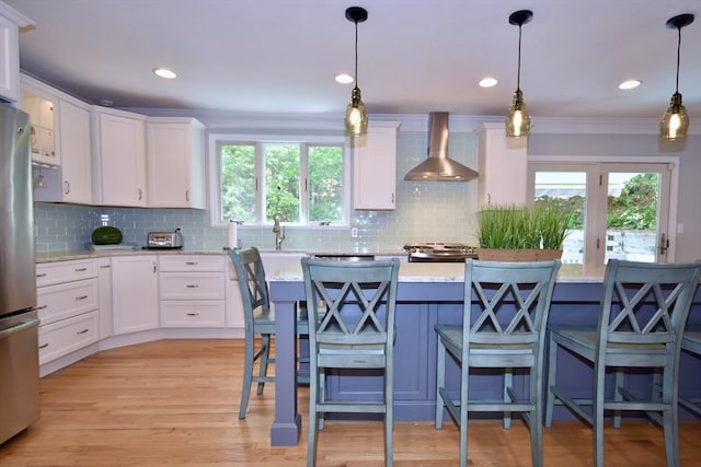24 Sheppard Rd, Bourne, MA 02562 - kitchen featuring wall chimney range hood, freestanding refrigerator, stove, white cabinetry, and ornamental molding