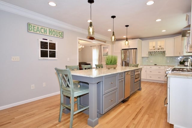 24 Sheppard Rd, Bourne, MA 02562 - kitchen with appliances with stainless steel finishes, gray cabinetry, white cabinetry, crown molding, and a breakfast bar area