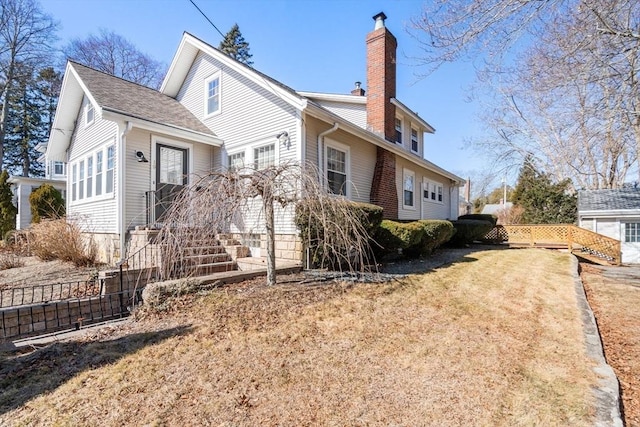 view of front facade with a front yard, fence, and a chimney