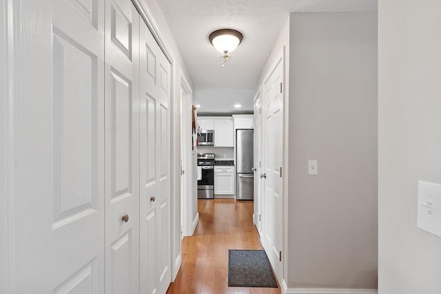 hallway featuring light wood-style floors and recessed lighting