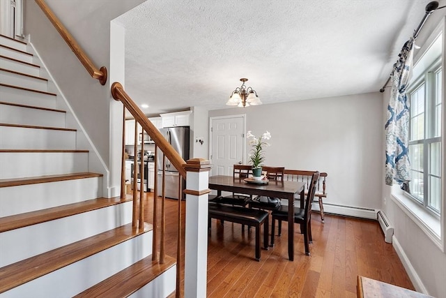 dining room featuring stairway, a healthy amount of sunlight, and baseboard heating