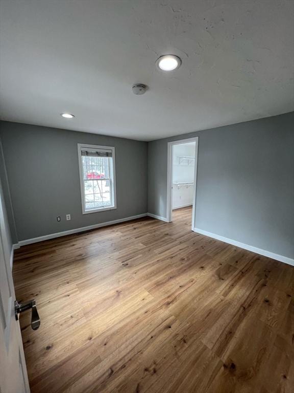 empty room featuring recessed lighting, light wood-style flooring, and baseboards