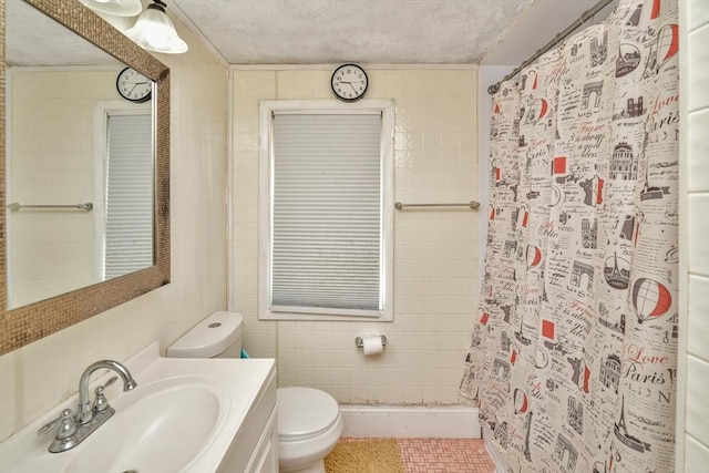 bathroom with toilet, a shower with shower curtain, vanity, and tile walls