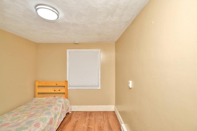 bedroom with wood finished floors and baseboards
